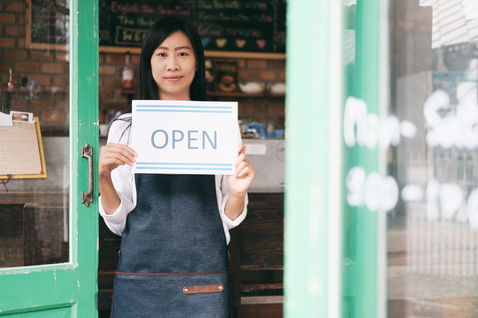 Open Small business: Happy owner of a cafe. Young startup owner small cafe shop
